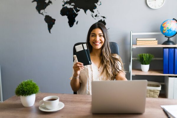 i-am-here-help-you-with-your-booking-travel-questions-female-sales-agent-holding-plane-tickets-while-s1-600x400